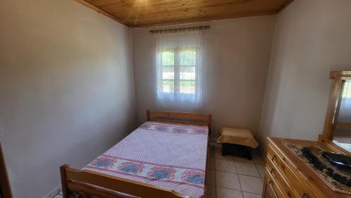 a small bedroom with a bed and a window at Peaceful 2-bedroom house 800m from beach in Neoi Epivates