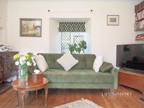 een woonkamer met een groene bank en een tafel bij Bury Meadow Lodge - Exeter - Train 5 min walk - Parking in Exeter