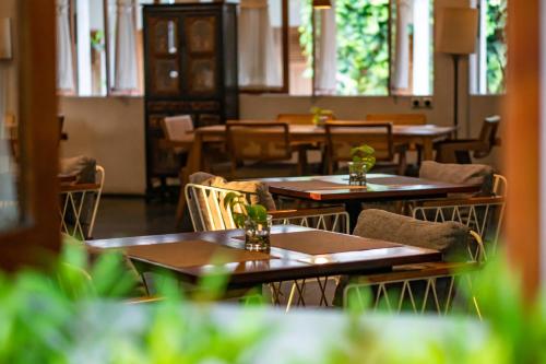 an empty restaurant with wooden tables and chairs at Hotel Blambangan in Banyuwangi