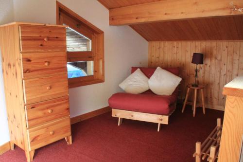 - une chambre avec une chaise rouge et une commode dans l'établissement VAL PIERRE VPD2 CENTER & SPACIOUS 8 Pers, à Châtel