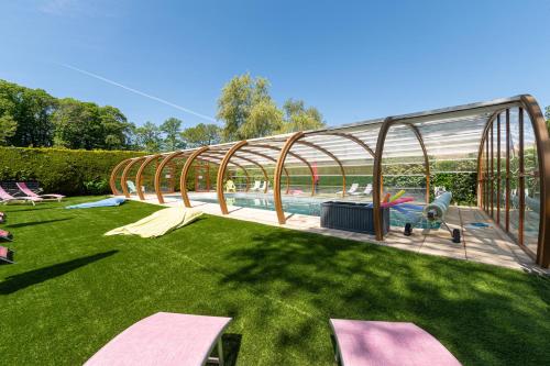 une cour arrière avec une piscine et une serre dans l'établissement Domaine de Lestroué- Île aux Moines, à La Vraie-Croix