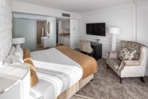 a bedroom with a bed and a chair and a television at Pepperclub Hotel in Cape Town
