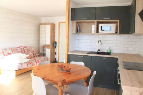 une cuisine et une salle à manger avec une table et des chaises en bois dans l'établissement VAL PIERRE VPS8 CENTER & MODERN 4 Pers, à Châtel