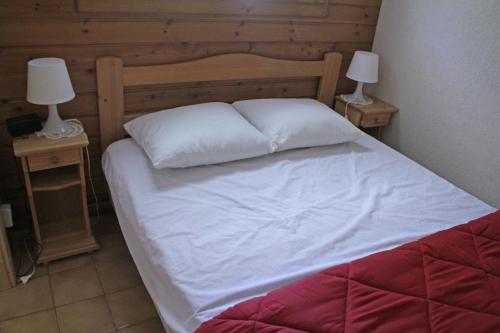 un lit avec des draps blancs et deux lampes sur des tables dans l'établissement VOINETTES VNB2 TELECABINE & MOUNTAIN 4 Pers, à Châtel