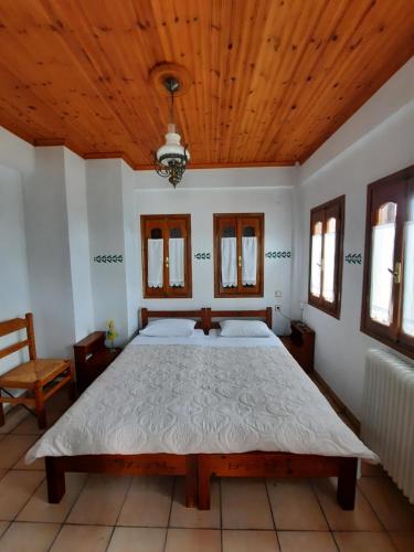 a bedroom with a large bed with a wooden ceiling at Milea Byron House Tsagarada in Tsagarada