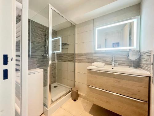 une salle de bain avec un lavabo, une douche et un miroir dans l'établissement PGH N15 - Vue Mer, Première Ligne & Parking Privé, à La Grande Motte
