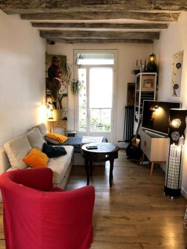 un salon avec un canapé et une table dans l'établissement Maison en bord de marne, à Saint-Maur-des-Fossés