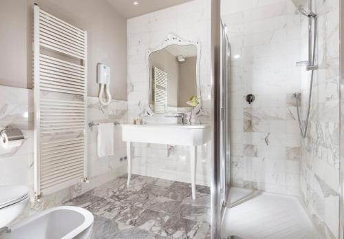 a white bathroom with a sink and a shower at Hotel Vittoria in Faenza