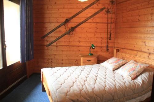 une chambre avec un lit dans un mur en bois dans l'établissement VERONICA VR49 NATURE & MOUNTAIN 6 Pers, à Châtel