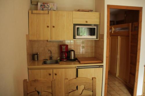 une petite cuisine avec un évier et un micro-ondes dans l'établissement VOINETTES VNB3 TELECABINE & MOUNTAIN 4 Pers, à Châtel