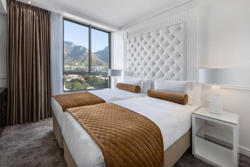 ein Schlafzimmer mit einem großen Bett und einem großen Fenster in der Unterkunft Pepperclub Hotel in Kapstadt