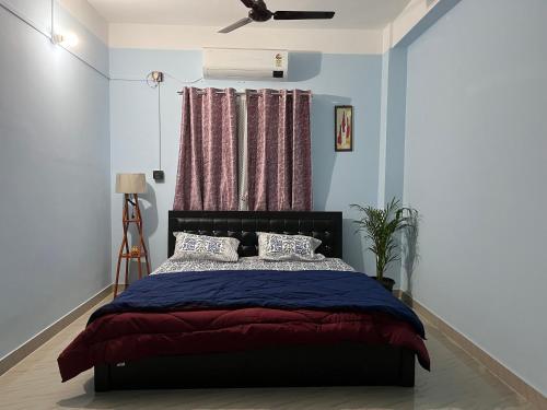 a bedroom with a bed with a red and blue blanket at Beltola serenity homestay in Guwahati
