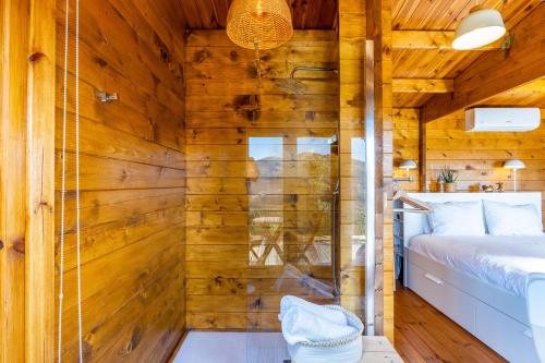a room with a wooden wall with a bed and a shower at Wood House Amazing View Douro in Raiva