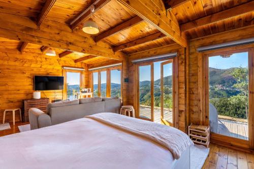 a bedroom with a large bed in a room with windows at Wood House Amazing View Douro in Raiva