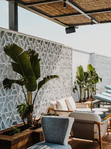 a room with chairs and plants on a wall at Aguas de Ibiza Grand Luxe Hotel - Small Luxury Hotel of the World in Santa Eularia des Riu