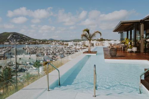a swimming pool with a view of a beach at Aguas de Ibiza Grand Luxe Hotel - Small Luxury Hotel of the World in Santa Eularia des Riu