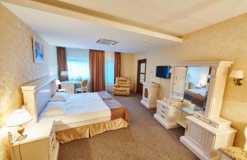 a hotel room with a bed and a mirror at Victoria Hotel na Zamkovoy Minsk in Minsk