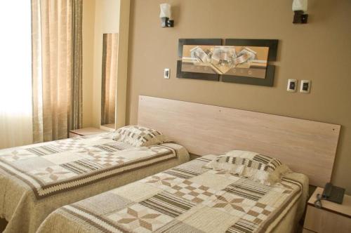 two beds sitting next to each other in a bedroom at Hotel Torresur Tacna in Tacna