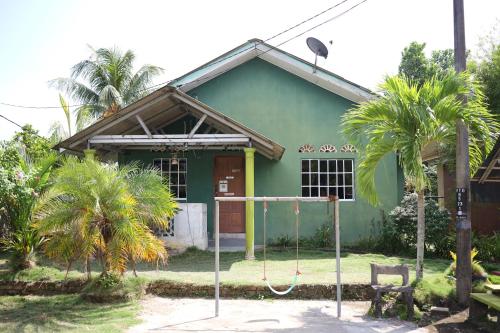 a house with a swing in front of it at Seri Tempurung Homestay in Cukai
