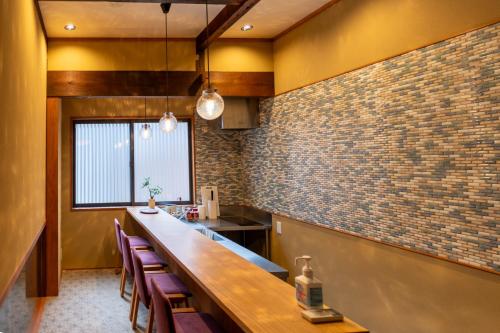 a kitchen with a long counter and a bar at Suiren Traditional Boutique Townhouse in Kyoto
