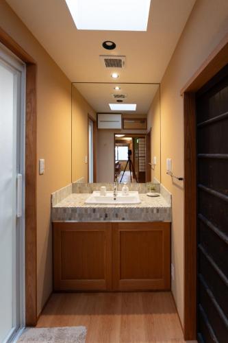 a bathroom with a sink and a mirror at Suiren Traditional Boutique Townhouse in Kyoto