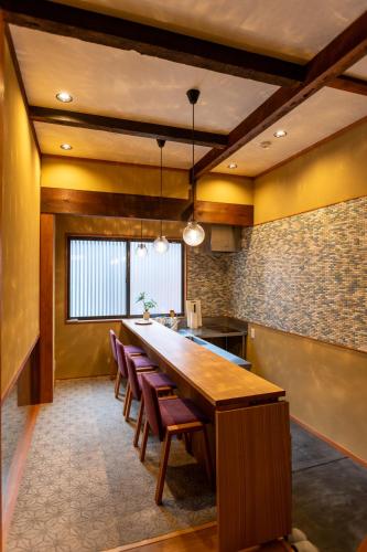 a large kitchen with a long wooden table and chairs at Suiren Traditional Boutique Townhouse in Kyoto