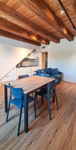a dining room table with blue chairs and a couch at Civico134 in Sirolo