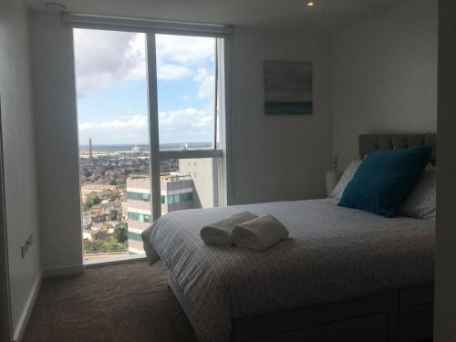 a bedroom with a bed and a large window at GRAND SERVICED APARTMENTS***** in Croydon