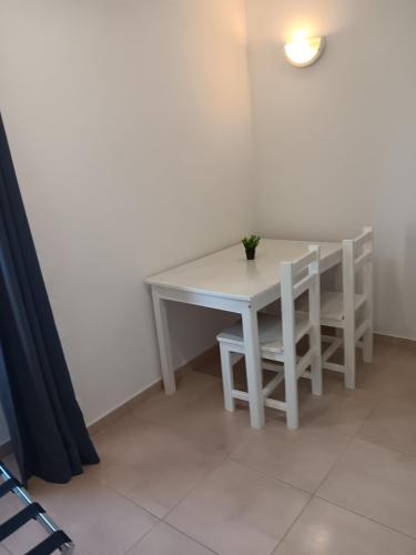 a white table and chairs in a room with a table at Flor de Sal in Vila Real de Santo António