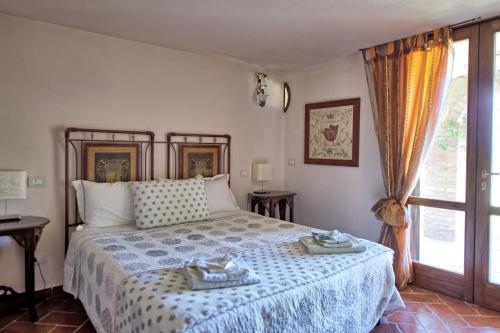 a bedroom with a large bed and a window at Villa Ulivi by PosarelliVillas in Lucignano