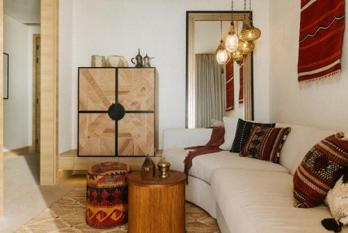 a living room with a white couch and a table at Our Habitas Ras Abrouq in Dukhān
