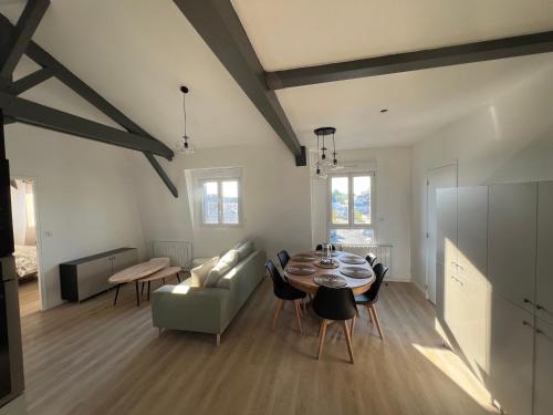 un salon avec une table et un canapé dans l'établissement L'Hostellerie des Vieux Plats LGT 6, à Gonneville-la-Mallet