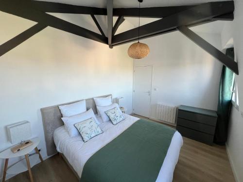 une chambre avec un grand lit avec des oreillers dans l'établissement L'Hostellerie des Vieux Plats LGT 6, à Gonneville-la-Mallet