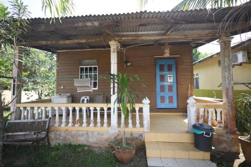 a wooden house with a porch and a blue door at Seri Tempurung Homestay in Cukai