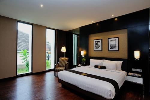 a large bedroom with a large bed and windows at Java Heritage Hotel Purwokerto in Purwokerto