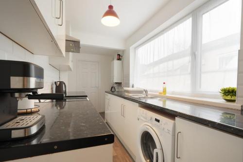 a kitchen with a washer and dryer on a counter at Grimsby City Centre stay in Grimsby