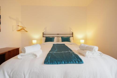 a bedroom with a large white bed with towels on it at Grimsby City Centre stay in Grimsby