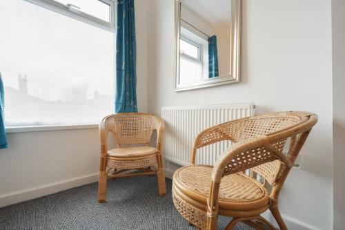 two chairs and a mirror in a room with a window at Grimsby City Centre stay in Grimsby