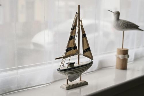 a small toy boat sitting on a shelf next to a bird at Grimsby City Centre stay in Grimsby