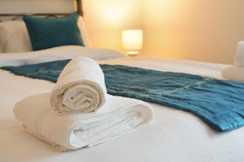 a pile of towels sitting on top of a bed at Grimsby City Centre stay in Grimsby