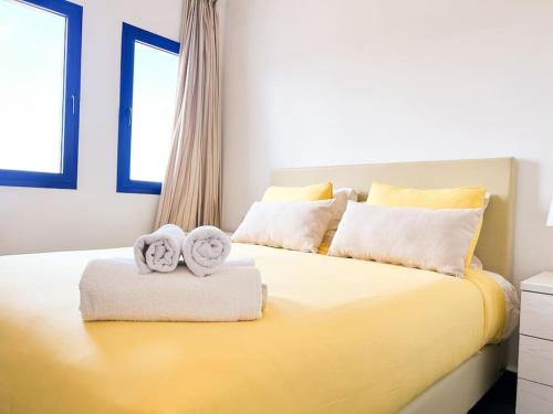 a bedroom with a yellow bed with towels on it at Superbe appartement vue sur mer in Marina Smir