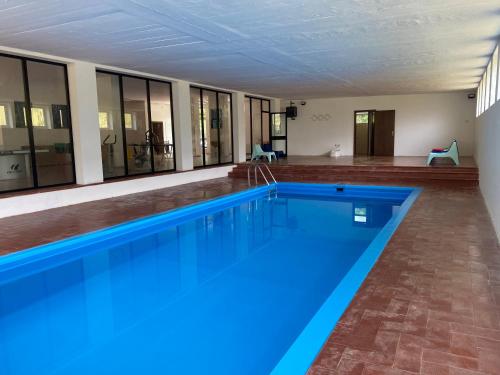 a large swimming pool with blue water in a building at Villaggio Santa Lucia in Ledro