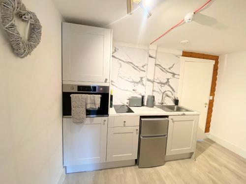 a white kitchen with a sink and a counter at Kaoglen Doe-Feature Bathroom-Cairngorms-Pets Allowed in Balnald