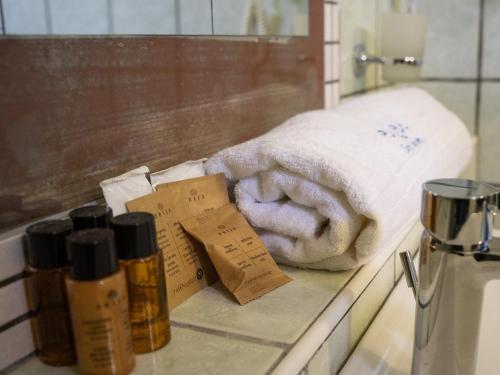 a bathroom counter with a towel and two bottles of soap at Boutique San Daniele B&B in Cirella
