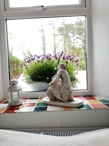 a statue of a woman sitting in a window at Cozy seaside cottage in Wexford