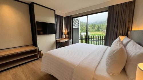 een hotelkamer met een bed en een groot raam bij Grand ASTON Puncak Hotel & Resort in Puncak