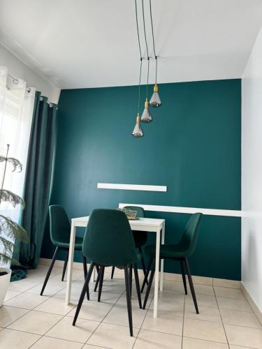 une salle à manger avec une table blanche et des chaises vertes dans l'établissement Stet Teodora, à Les Pavillons-sous-Bois