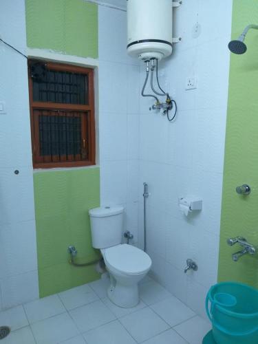 a bathroom with a toilet and a window at Prestige Villa in Shimla