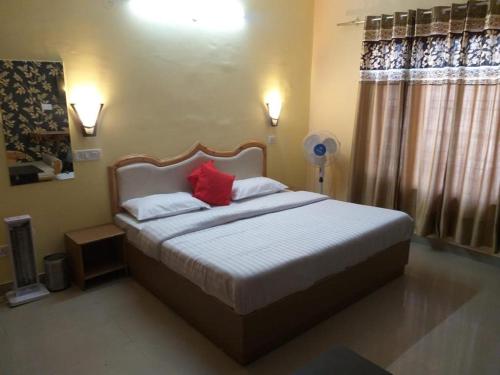 a bedroom with a bed with two red pillows at Prestige Villa in Shimla