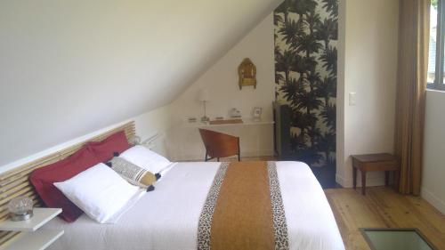 a bedroom with a large bed and a desk at L'Atelier in Bayeux